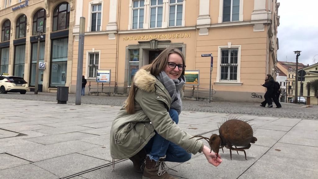 Eine Frau streckt einem virtuellen Augmented Reality-Bodentier ihre Hand zum Fressen hin