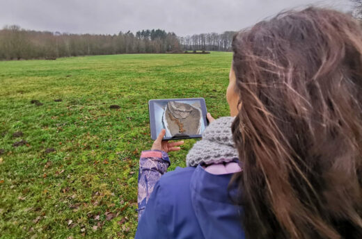 Eine Frau steht mit einem Tablet im Museumspark