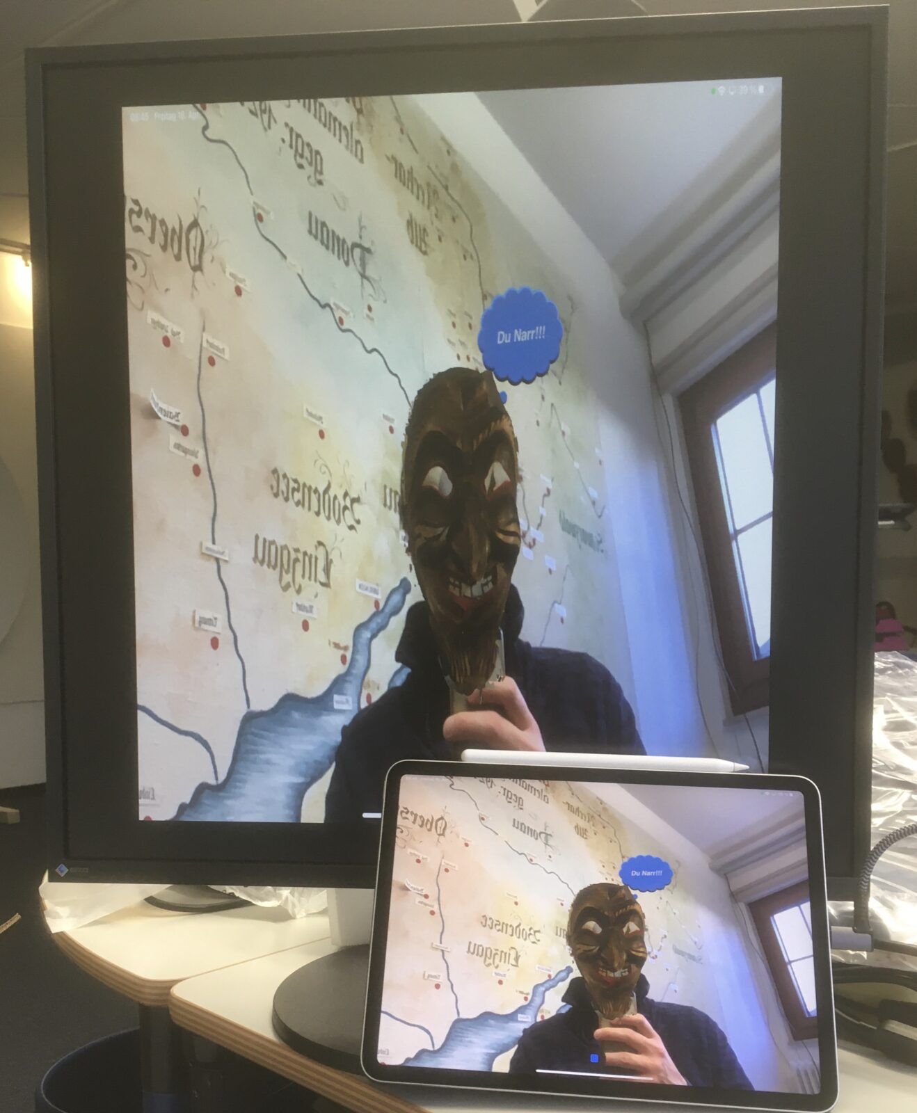 Ein Mann macht ein Selfie seines Spiegelbilds mit Maske. Eine virtuelle Denkblase erscheint über seinem Kopf mit "Du Narr!!!".
