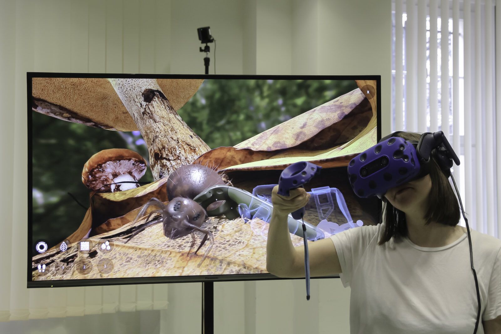 Eine Nutzerin betrachtet einen Springschwanz mit einer 3D-Brille. Im Hintergrund ist der Monitor zu sehen mit dem Springschwanz zu sehen.