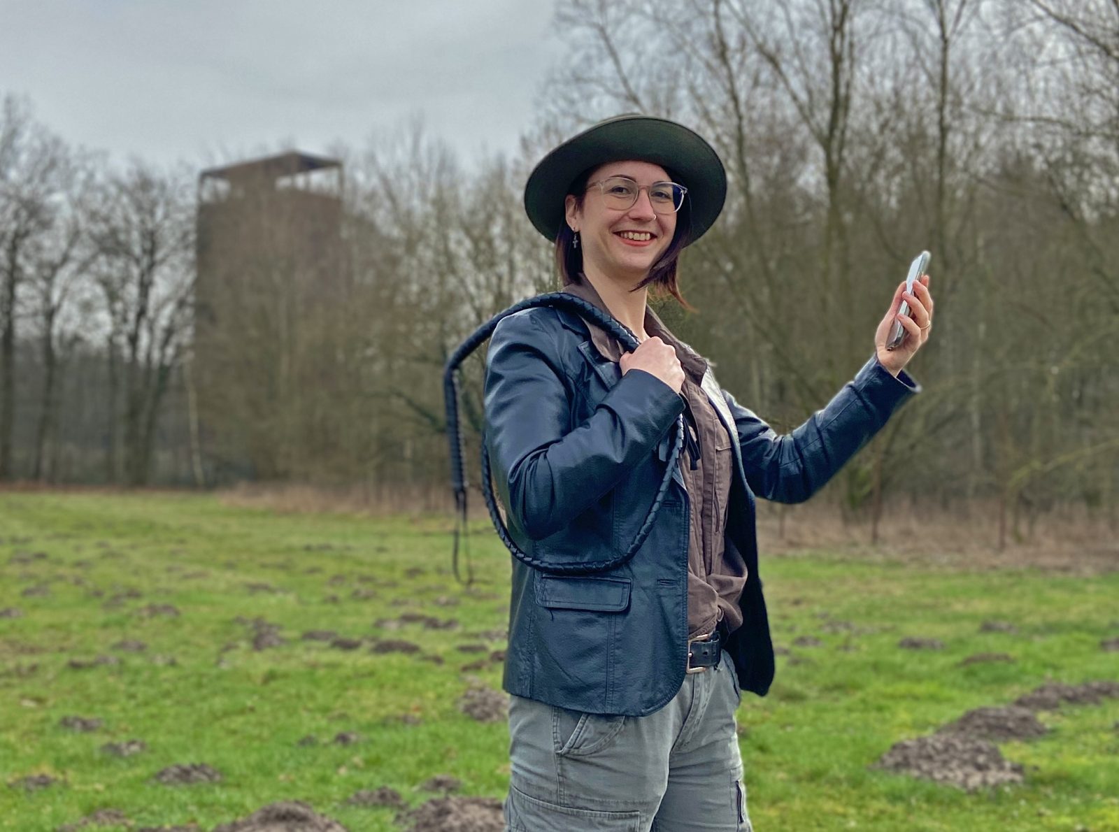 Eine Frau steht mit einem Handy im Museumspark.