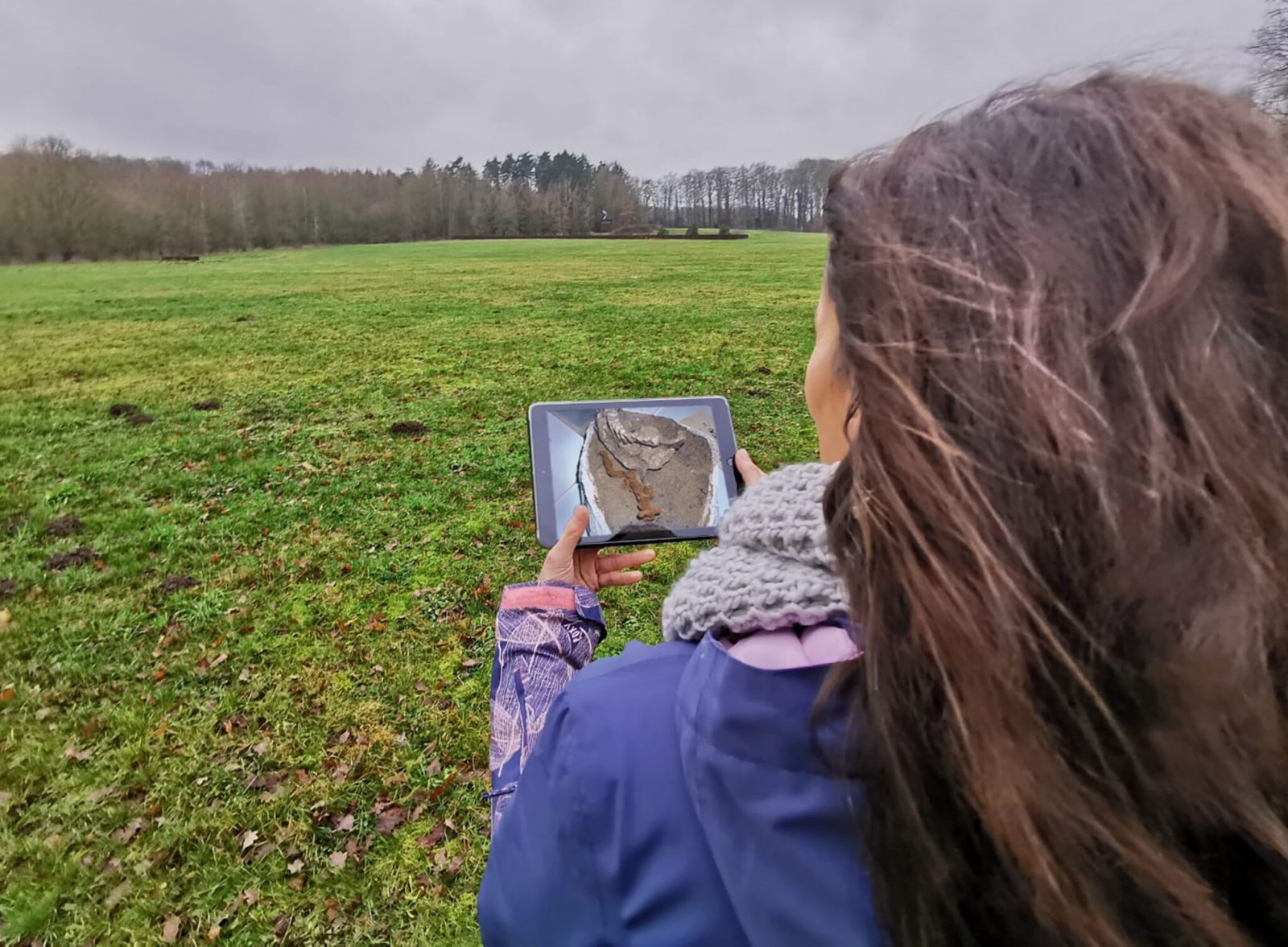 Eine Frau steht mit einem Tablet im Museumspark.