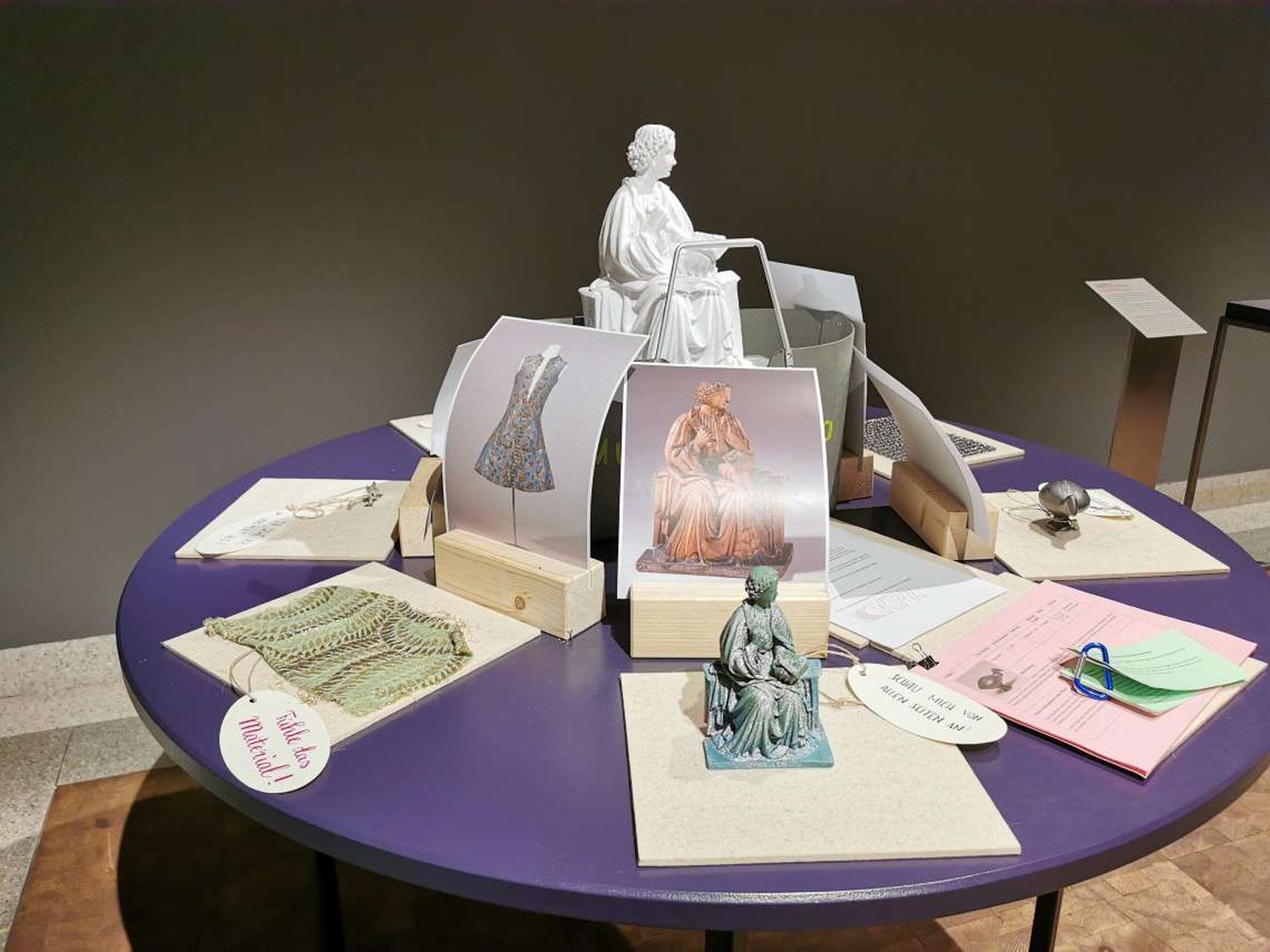 Auf einem Tisch sind verschiedenen Objektfotos, 3D-Drucke, Materialproben und Lehrmaterialien ausgebreitet.